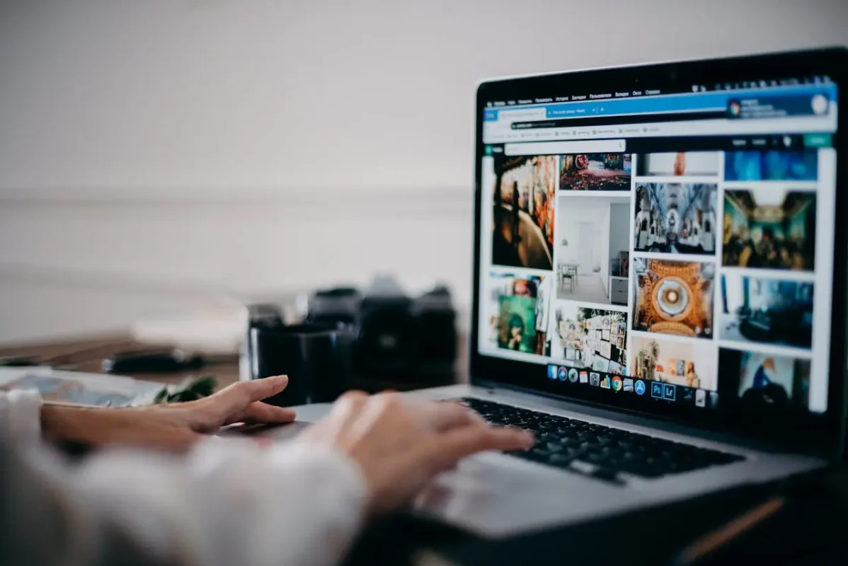 A person browsing a gallery of website design inspirations on a laptop, representing the creative process of custom website design with visually engaging layouts and elements.