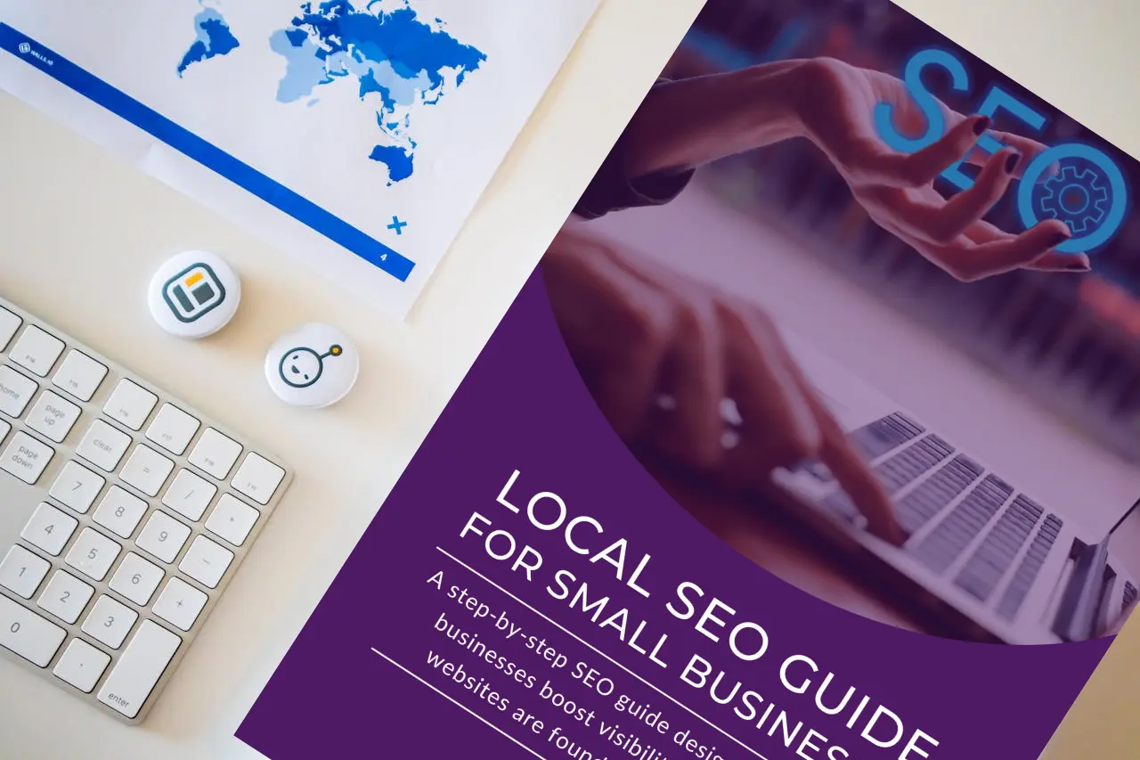 Flatlay of a modern desk with a white keyboard and the LaunchPad Local SEO Guide for Small Businesses — a digital resource for website optimization.