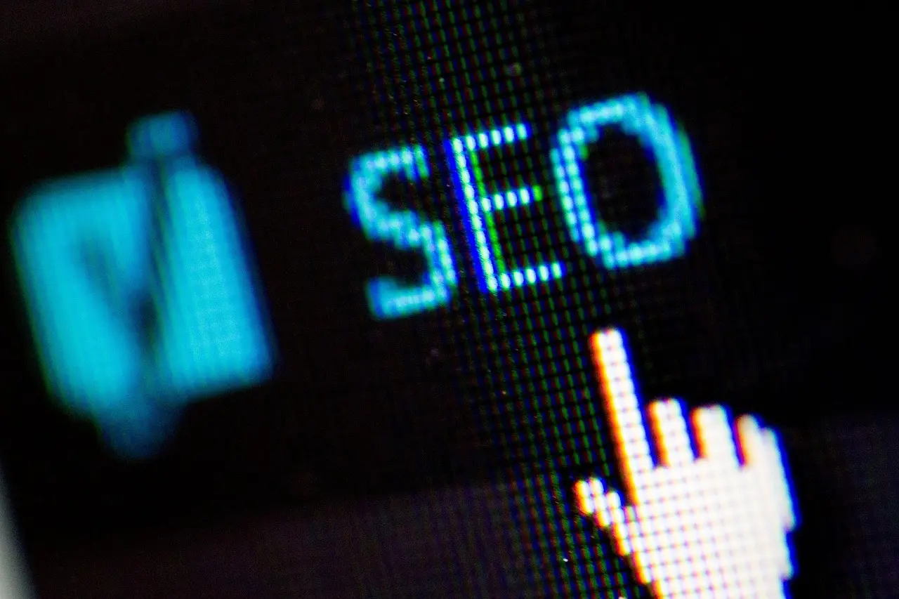 Close-up of a digital screen displaying the pixelated word 'SEO' in bright blue, with a white cursor arrow pointing towards it, symbolizing precise technical optimization. This image represents technical SEO strategies for freelancers and small businesses from Launchpad Web Designs, focusing on improving website performance, crawlability, and indexing for better search engine visibility.