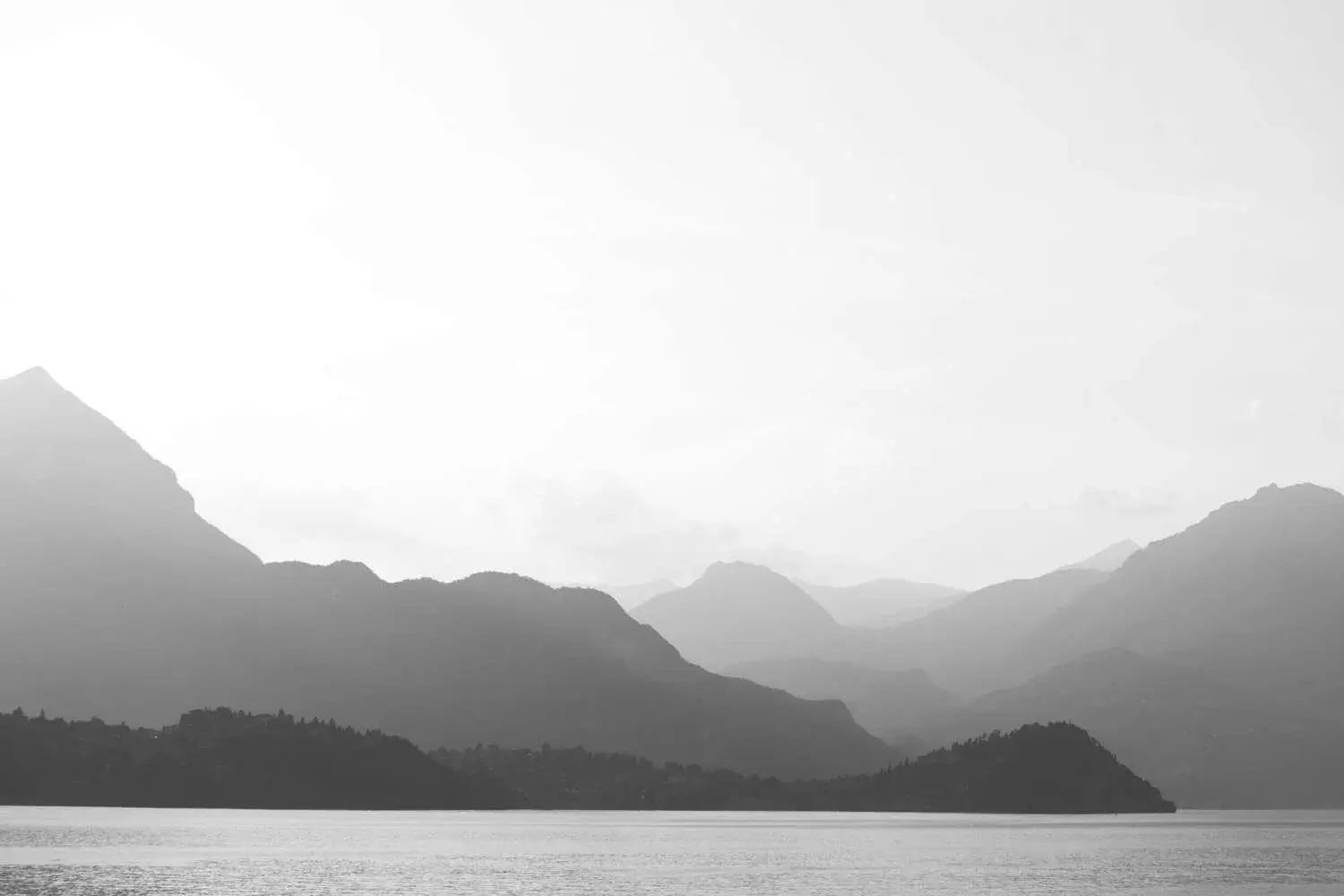 A serene, monochromatic landscape of layered mountains and calm water, serving as a background image for a website maintenance report. This image conveys the stability, clarity, and comprehensive overview provided by Launchpad Web Designs' maintenance services.