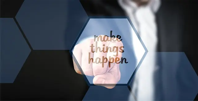 A blurred image of a person in a suit pointing a finger towards the viewer, with a translucent blue hexagonal overlay that reads 'make things happen.' This image represents the decisive action and impactful results that successful freelancers deliver, demonstrating how effective freelance portfolio examples showcase tangible outcomes to win clients.